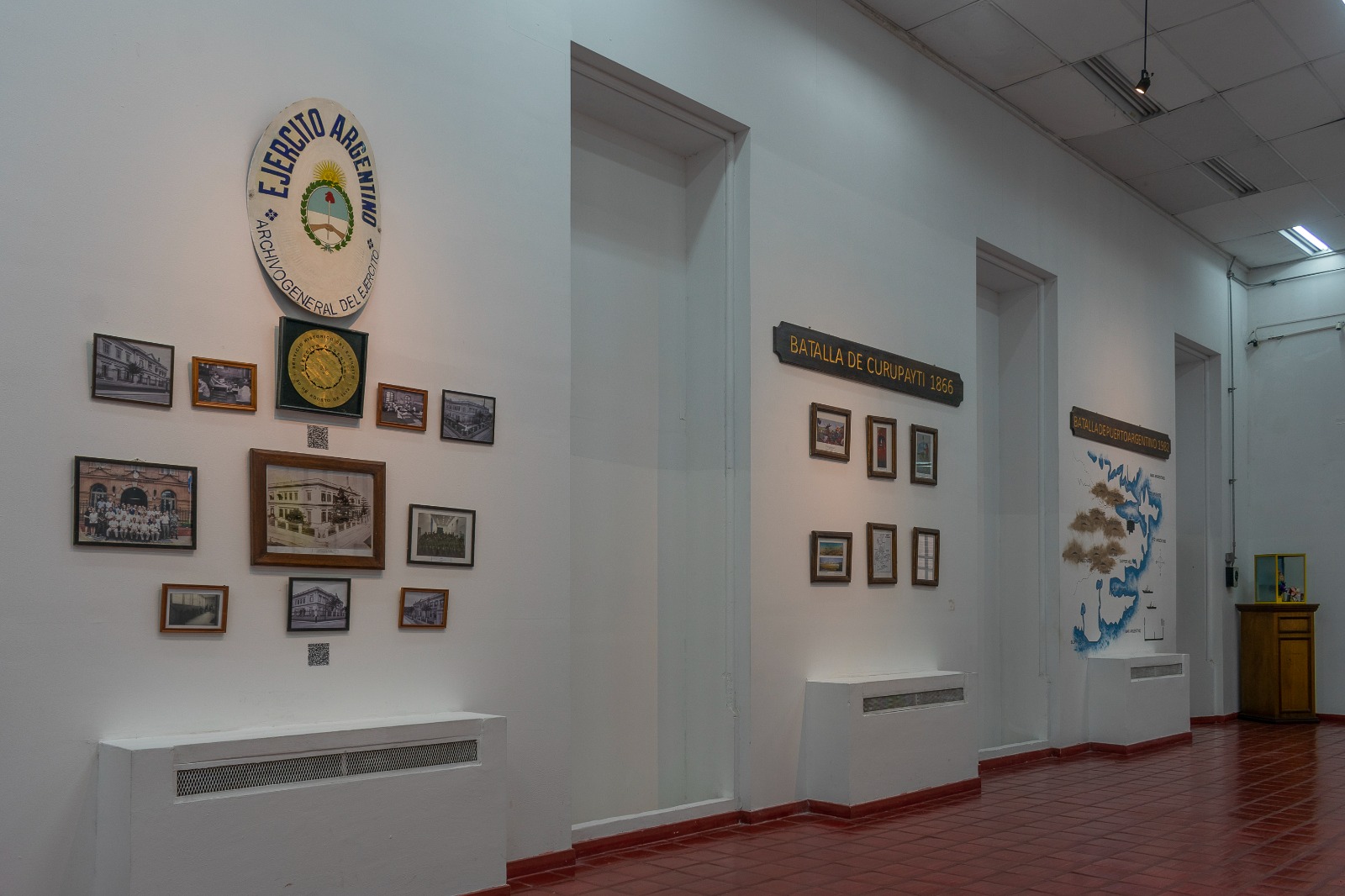 La entrada al Taller del Histórico: Centro de preservación patrimonial donde el Servicio Histórico del Ejército realiza trabajos de herrería y carpintería. Ventanales cuadrangulares y escudos heráldicos enmarcan esta puerta protegida por un toldo con estructura de hierro, parte esencial de nuestra historia nacional.