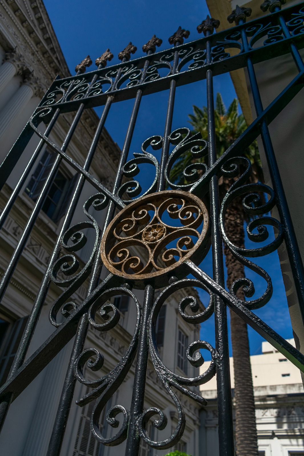 Reja de la fachada principal: Elaborada fusión de hierro, ladrillos y ventanas monumentales en una fachada que conjuga estilos arquitectónicos eclécticos, desde el italianizante hasta el industrial británico del siglo XIX.